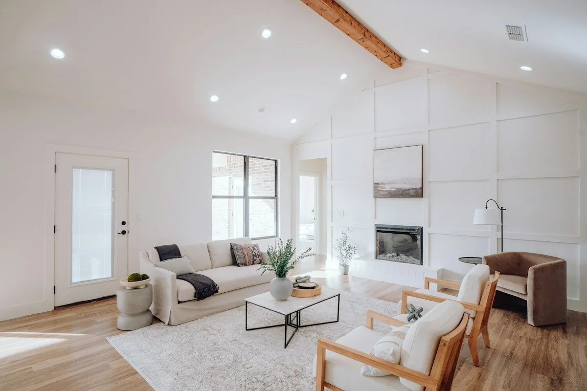 Sunlit living area with clean floors, seating and finished wood details